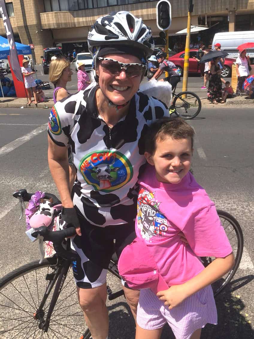 Kerrin Bain standing next to her bicycle with her son smiling
