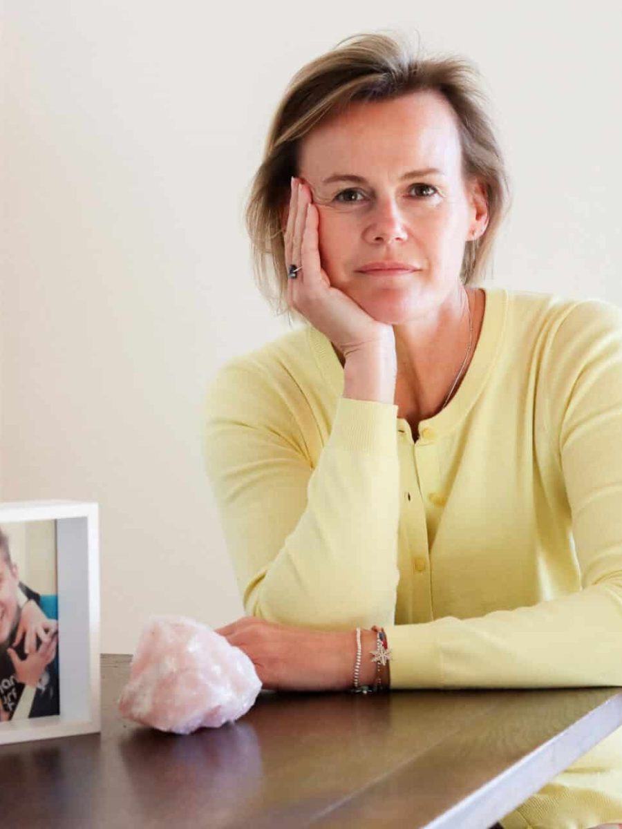 Kerrin Bain seated at a table with a framed picture of two chidren